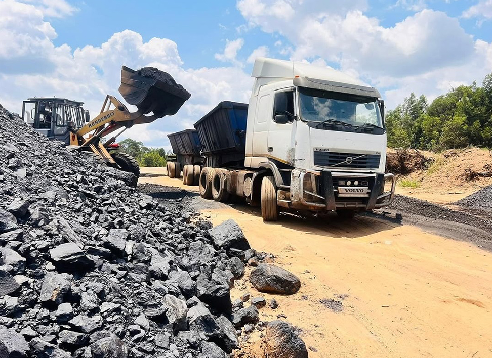 Side tipper truck being loaded with coal by a front end loader
